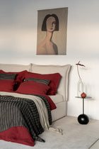 Detailaufnahme der karminroten Leinen Bettwaesche, Stoffstruktur und Kokosknoepfe