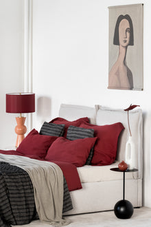 Karminrote Leinen Bettwaesche, seitliche Ansicht des Bettes im Schlafzimmer