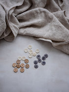 Locker fallende naturfarbene Leinenbettwaesche auf Bett