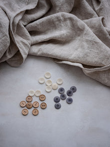 Locker fallende naturfarbene Leinenbettwaesche auf Bett