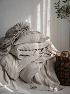 Leinen Bettwaesche Set Natur, gestapelte Kissen und Decken