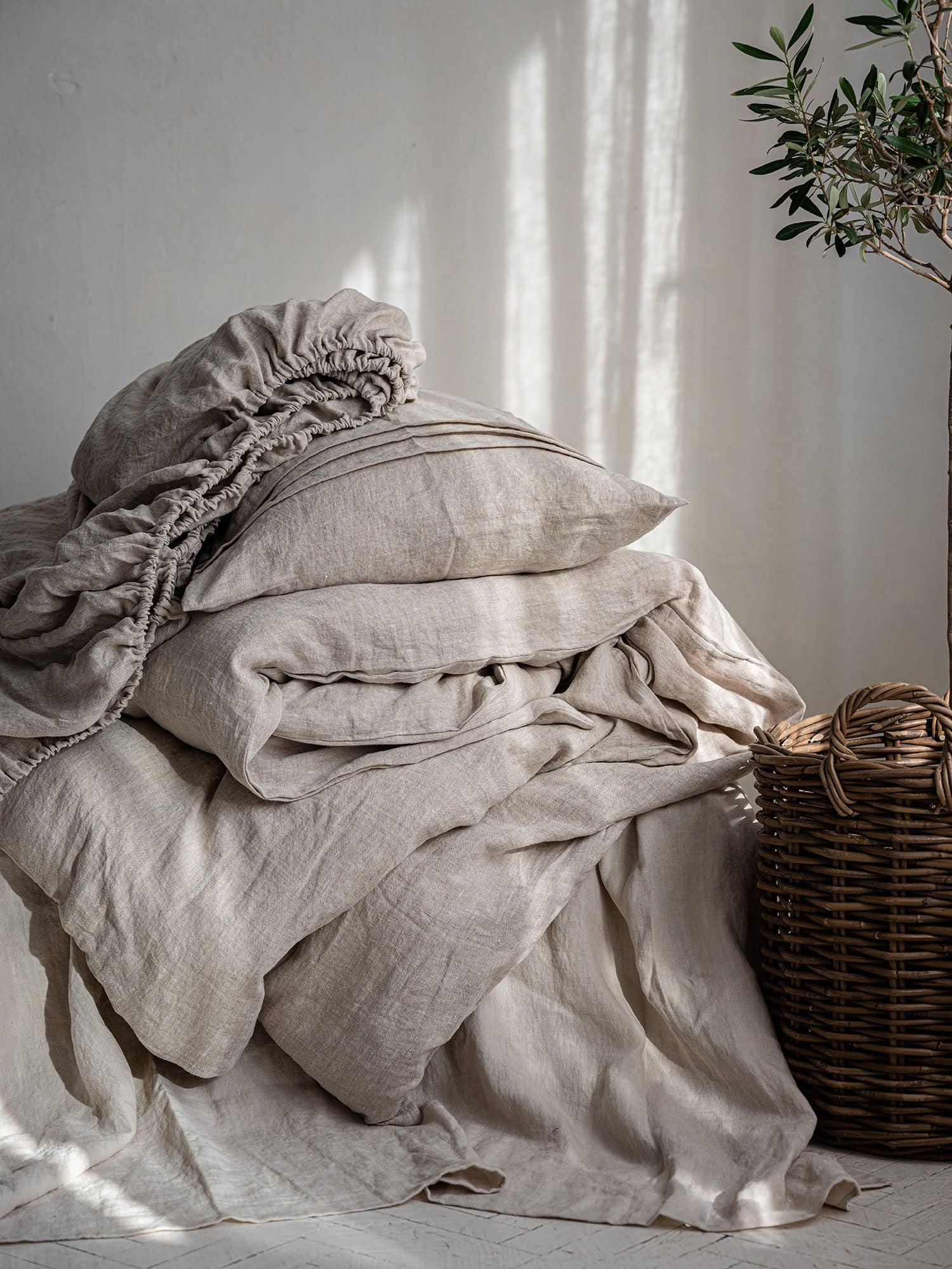 Leinen Bettwaesche Set Natur, gestapelte Kissen und Decken