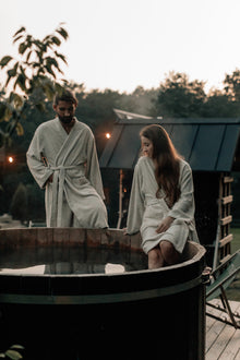 Zwei Personen im Leinen Frottee Bademantel, sitzend auf Bank