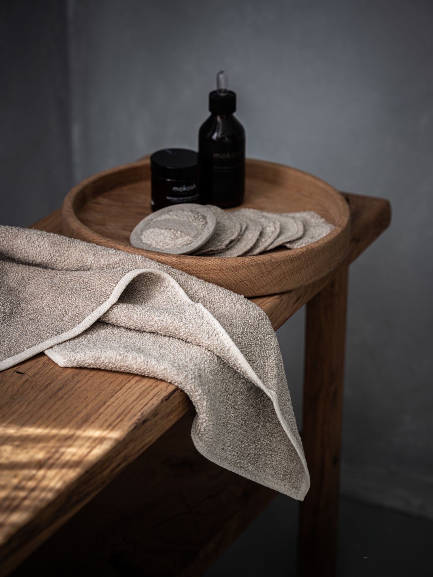 Leinen Handtuch und Pflegeprodukte, Detailaufnahme auf Holztisch