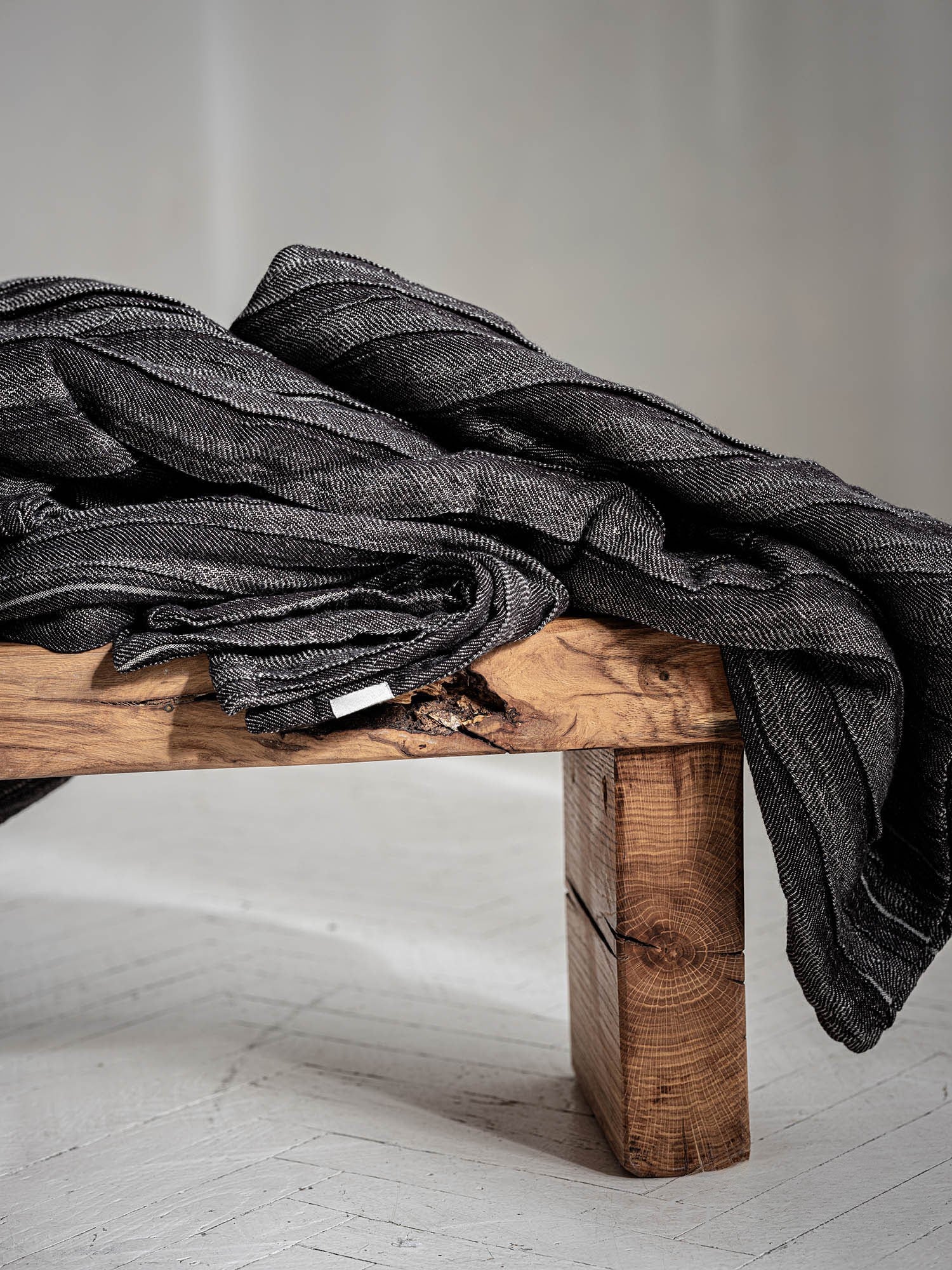 Geraffte Leinen Tagesdecke in Anthrazit, gestapelt auf Holzhocker