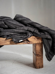 Geraffte Leinen Tagesdecke in Anthrazit, gestapelt auf Holzhocker