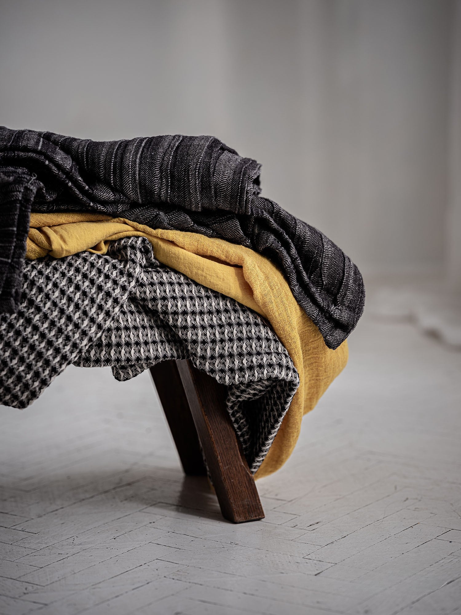 Geraffte Tagesdecke aus Leinen Anthrazit locker ueber Stuhl gelegt