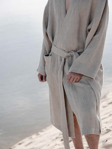 Zwei Personen im Waffel Bademantel Natur, am Strand sitzendZwei Personen im Waffel Bademantel Natur, am Strand sitzend