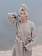 Frau im Waffel Leinen Bademantel Natur, stehend am Strand